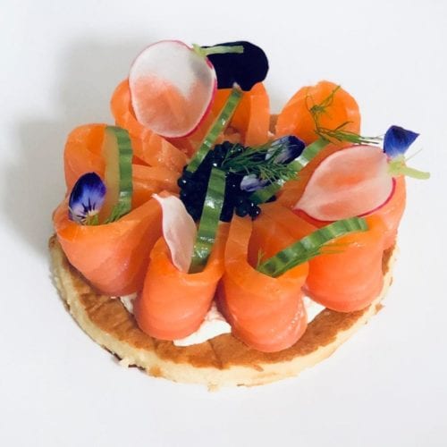 Sliced salmon with cucumber on a biscuit