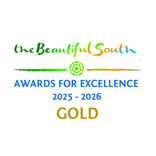 Hurley House - Logo for the Beautiful South Awards for Excellence 2025-2026. The text is styled in green, blue, and gold with a small green rose graphic. The word GOLD appears prominently at the bottom.